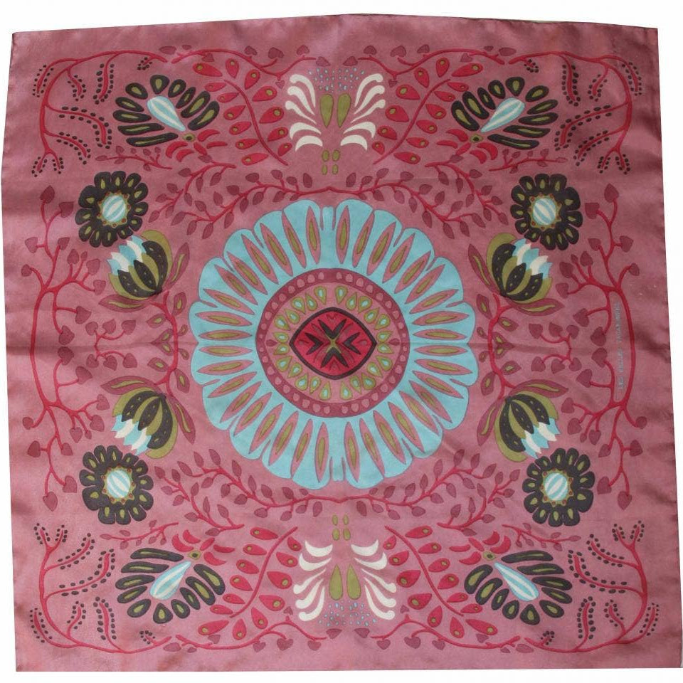 Decorative pink fabric with a central blue floral design and surrounding patterns