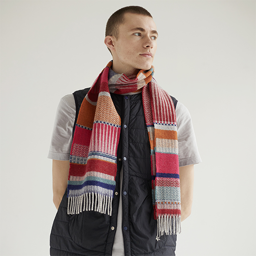 Man wearing a colorful scarf with a neutral background