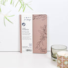 Sustainable notebook packaging with a plant and candle on a white background