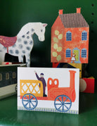 Colorful toy train card with a horse and house in the background