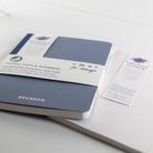 Blue notebook with white label on a light gray surface