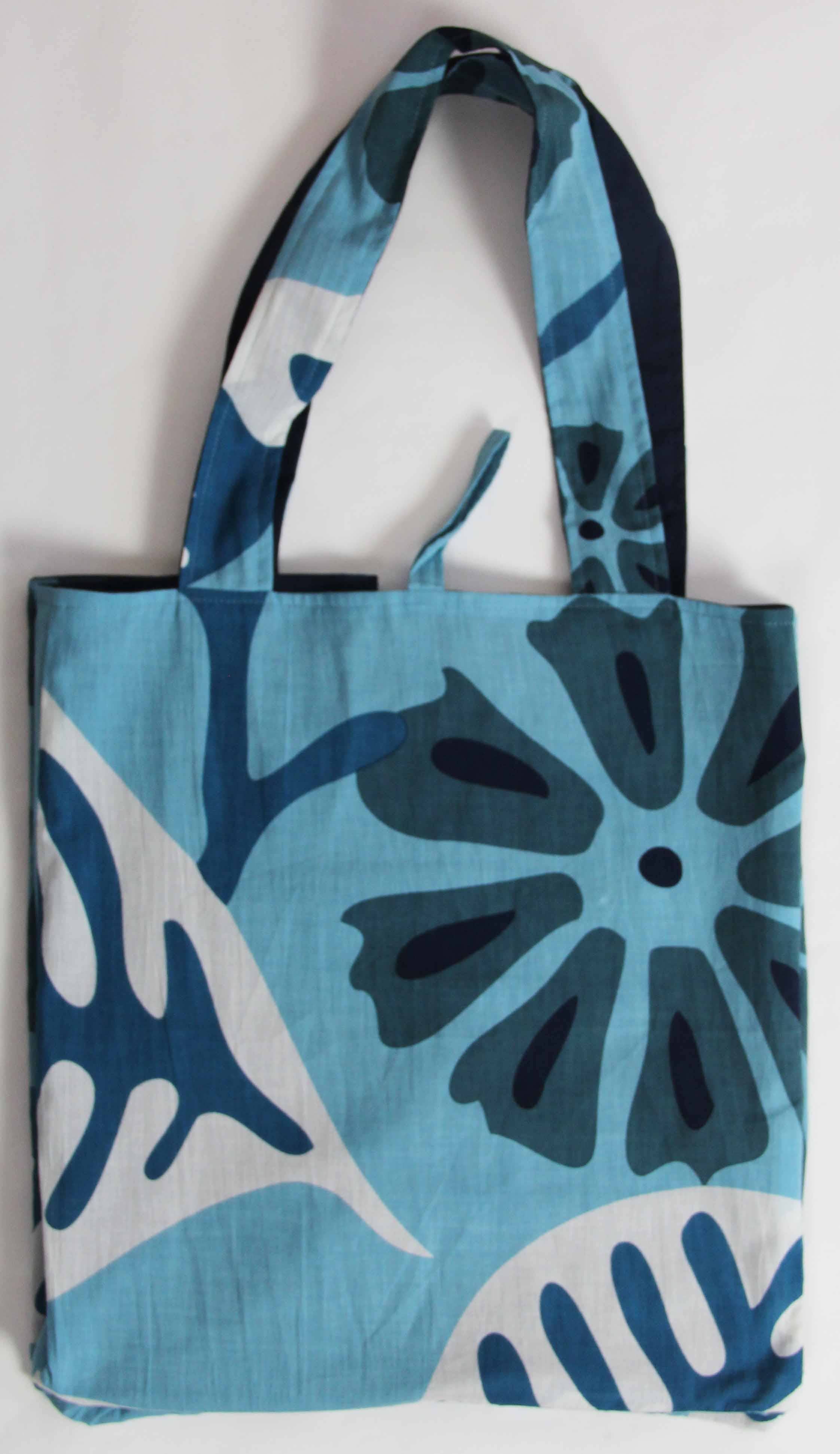 Blue and white tote bag with floral pattern on a light gray background