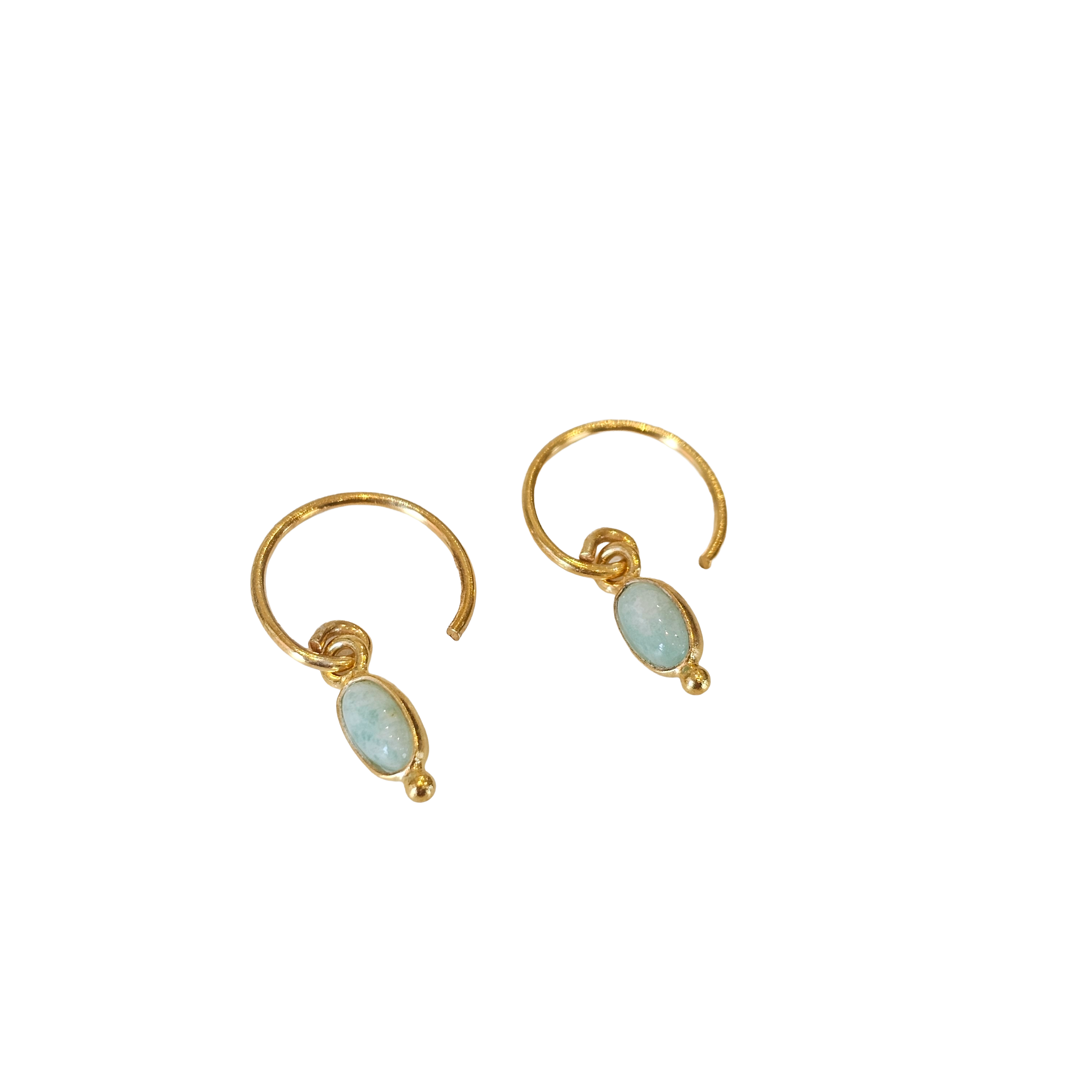 Gold earrings with light blue gemstones on a white background