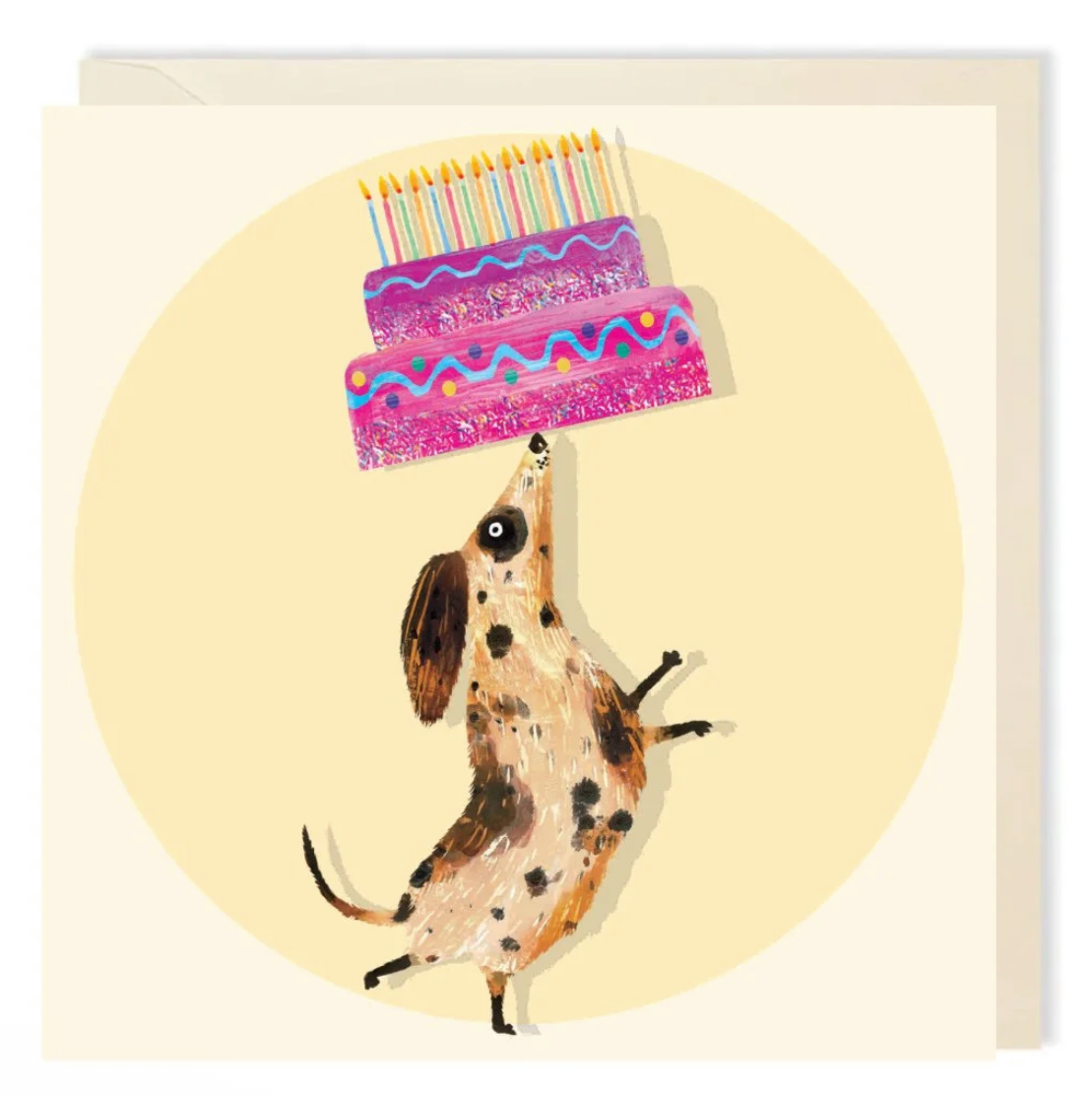 An illustrated card featuring a dog on hind legs, balancing a birthday cake on it’s nose. The cake is two-tiered and pink with a colourful pattern and many colourful candles on top.