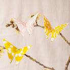 Butterfly-shaped decorations on branches with a neutral background