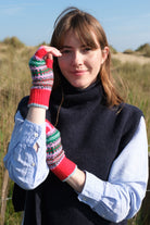 Woman wearing colorful mittens outdoors with a clear sky