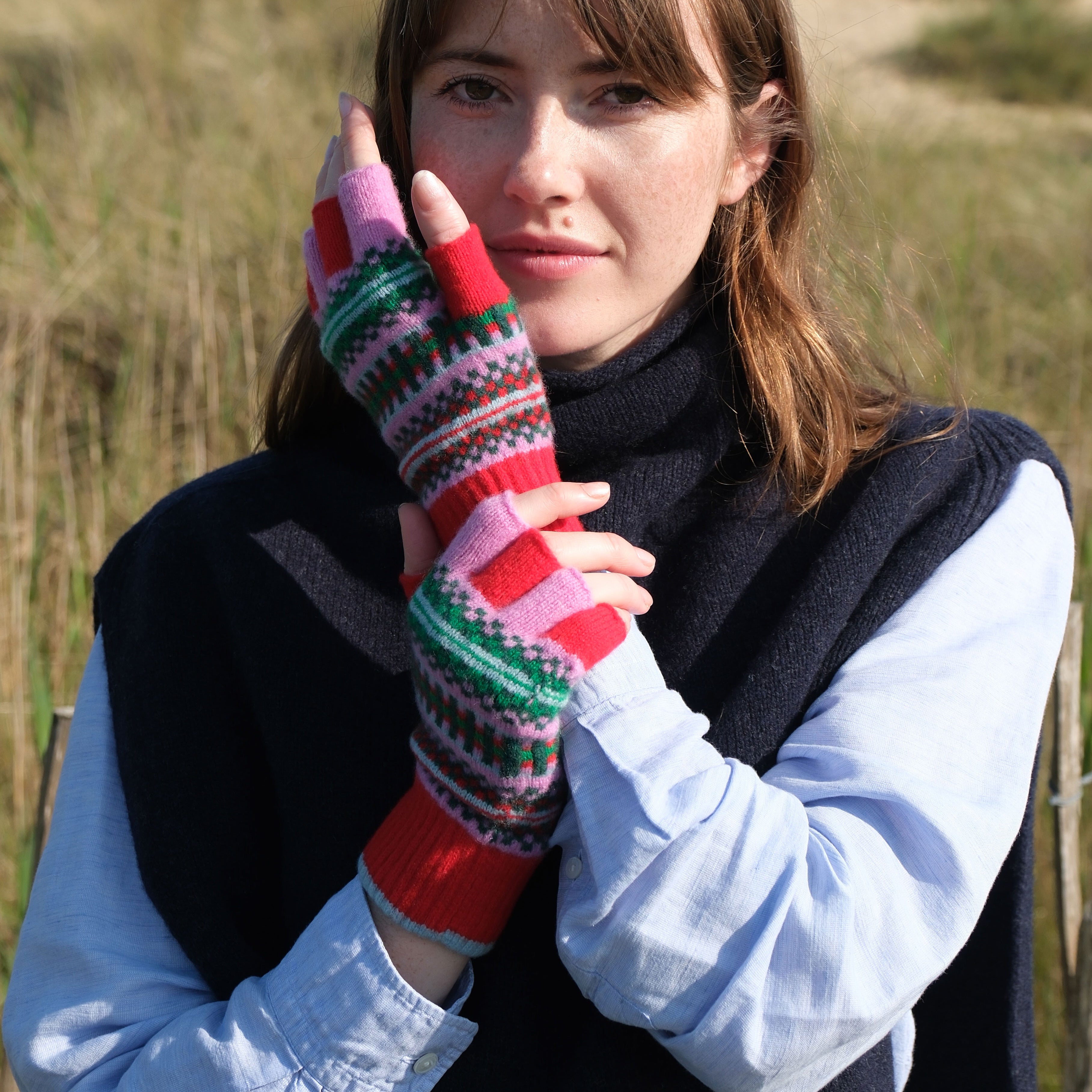 Woman wearing colorful fingerless gloves in a natural setting