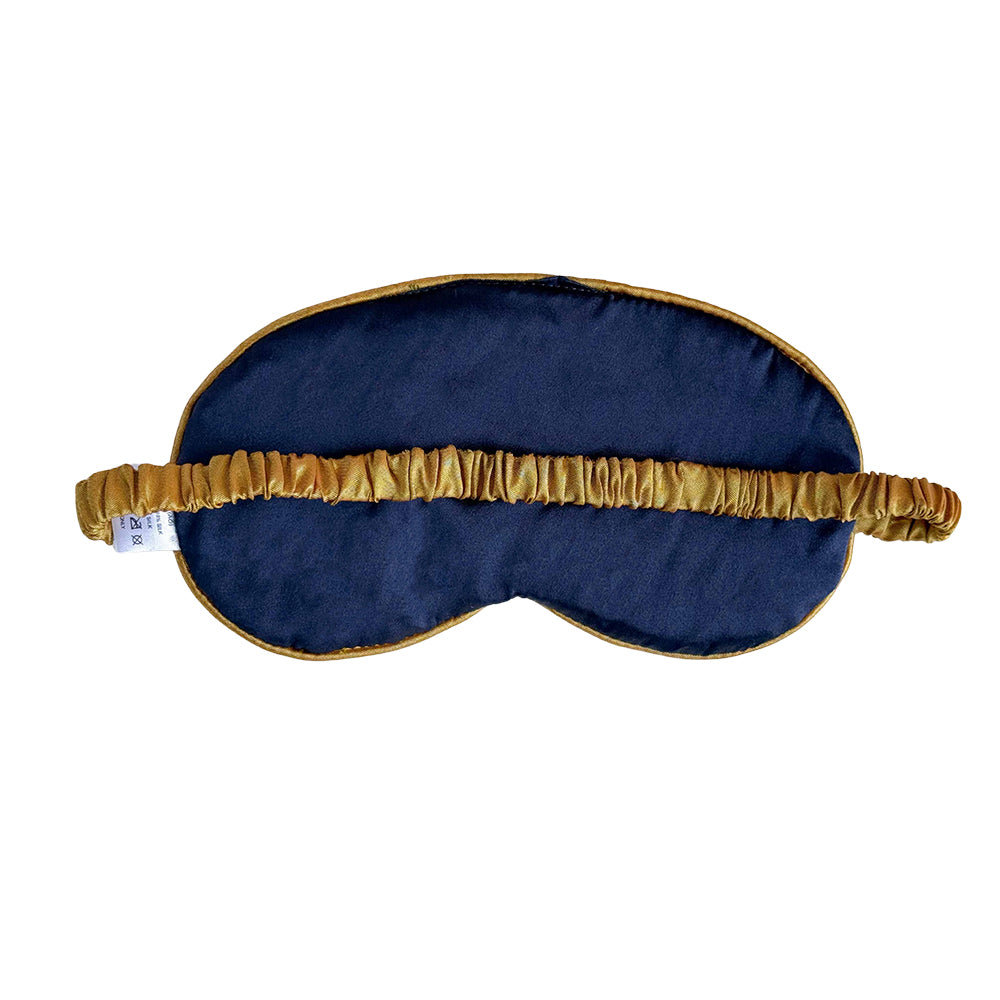 Navy blue sleep mask with gold trim on a white background
