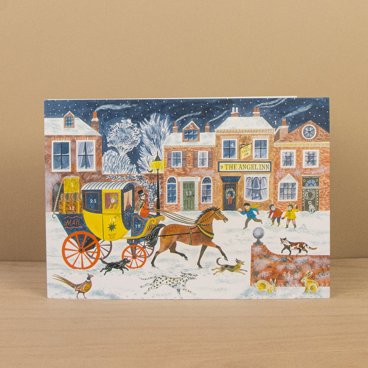 Card with a winter scene featuring a horse-drawn carriage and people in front of 'The Angel Inn'.