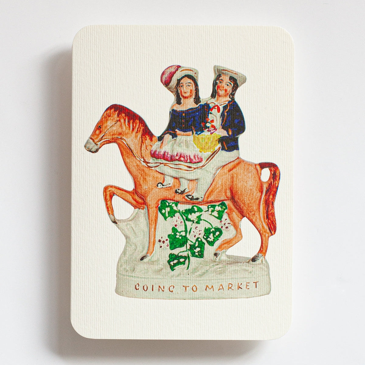 Notebook with a vintage-style illustration of two people on a horse, titled 'Going to Market', on a white background.