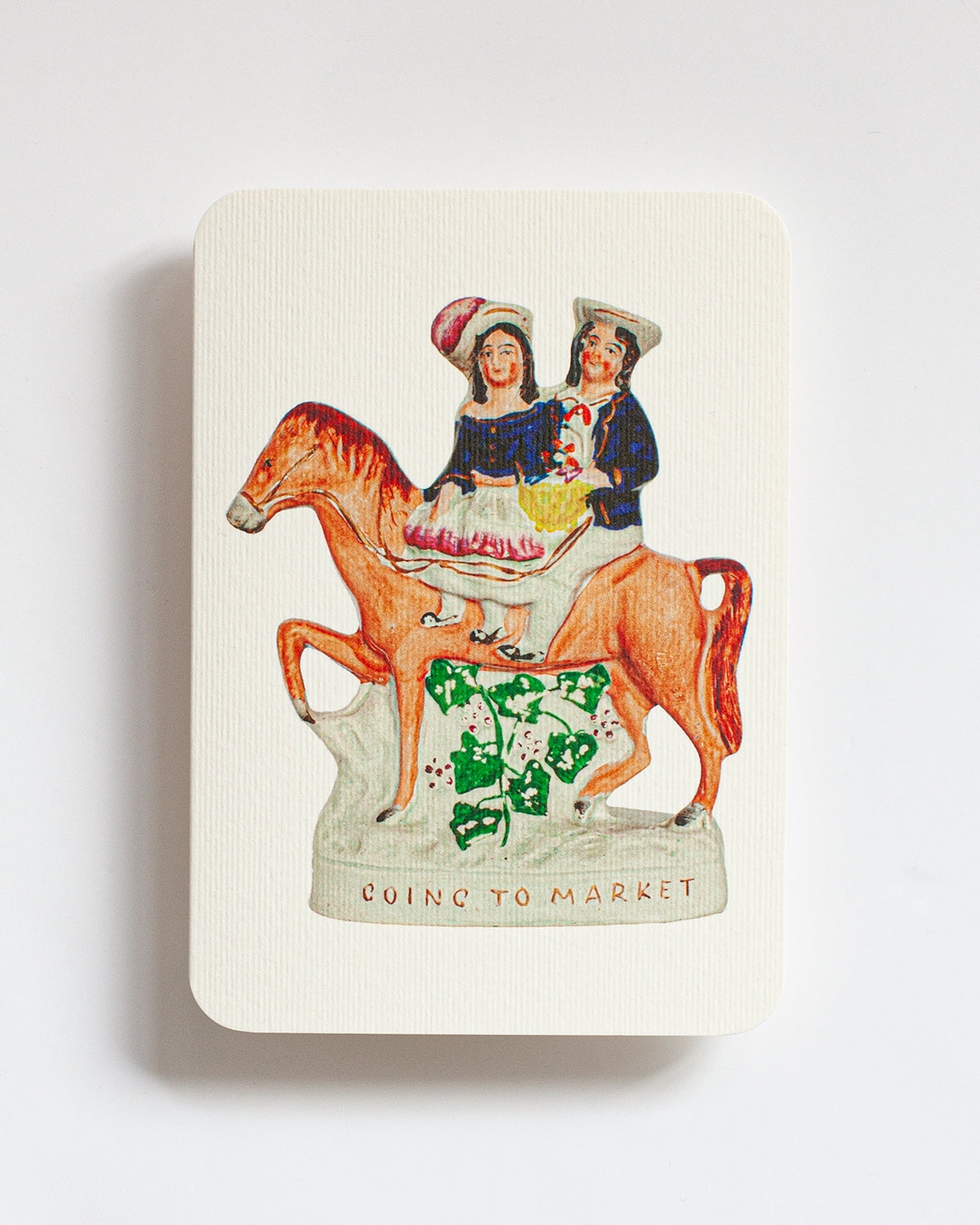 Notebook with a vintage-style illustration of two people on a horse, titled 'Going to Market', on a white background.