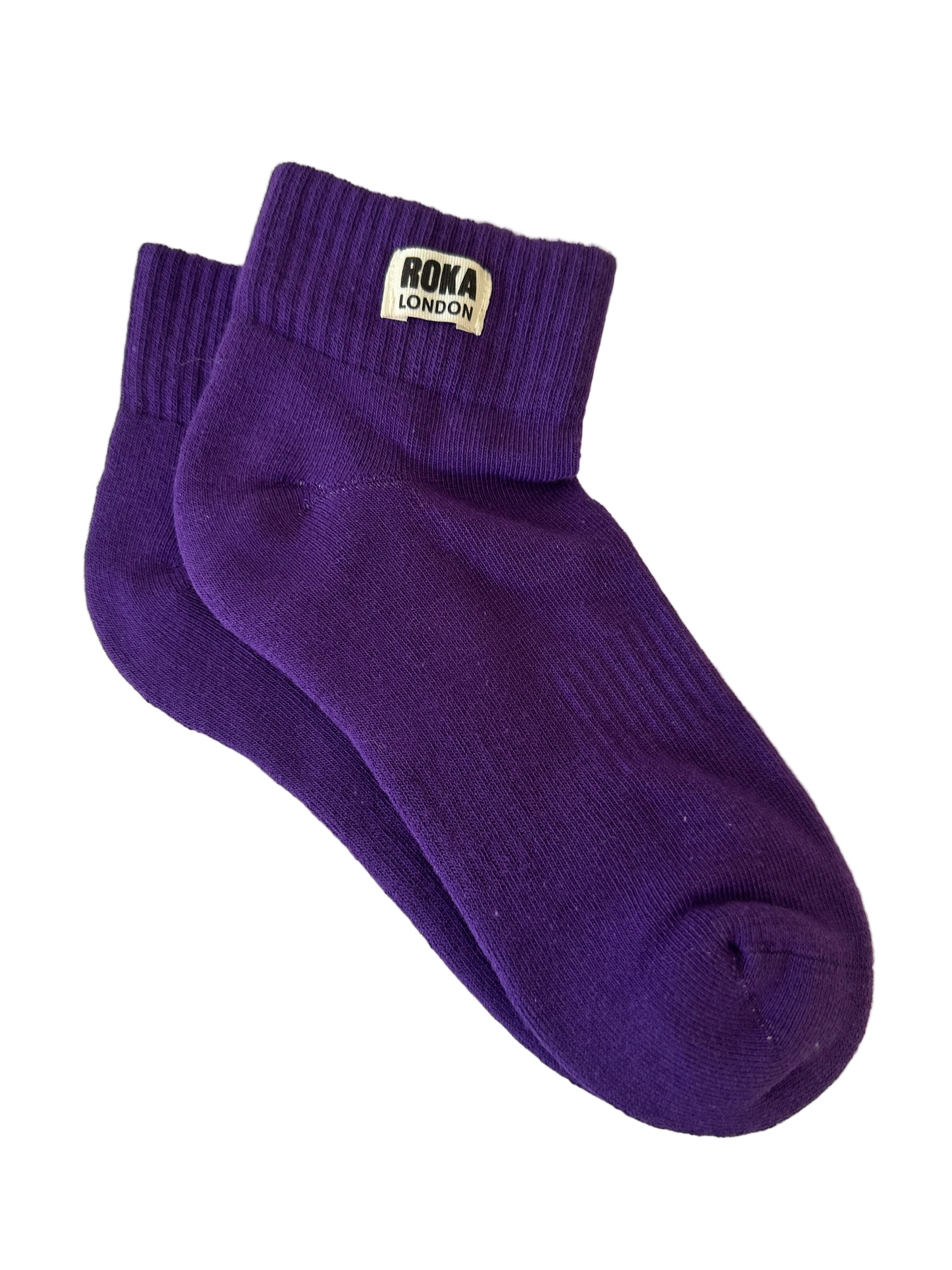 Purple sock with 'Roka London' label on a sheet of paper