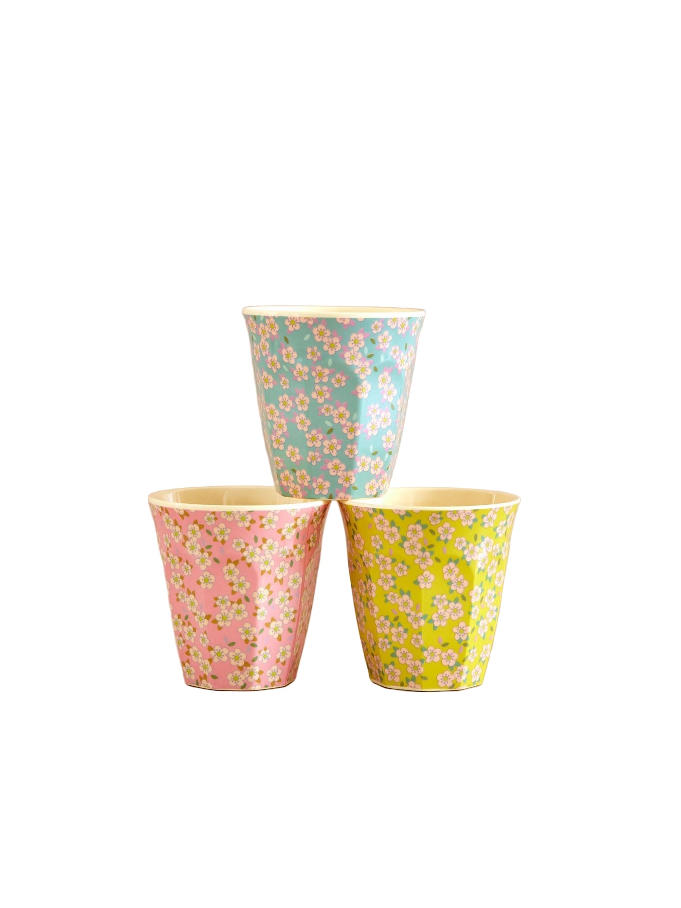 Three floral-patterned cups on a beige background