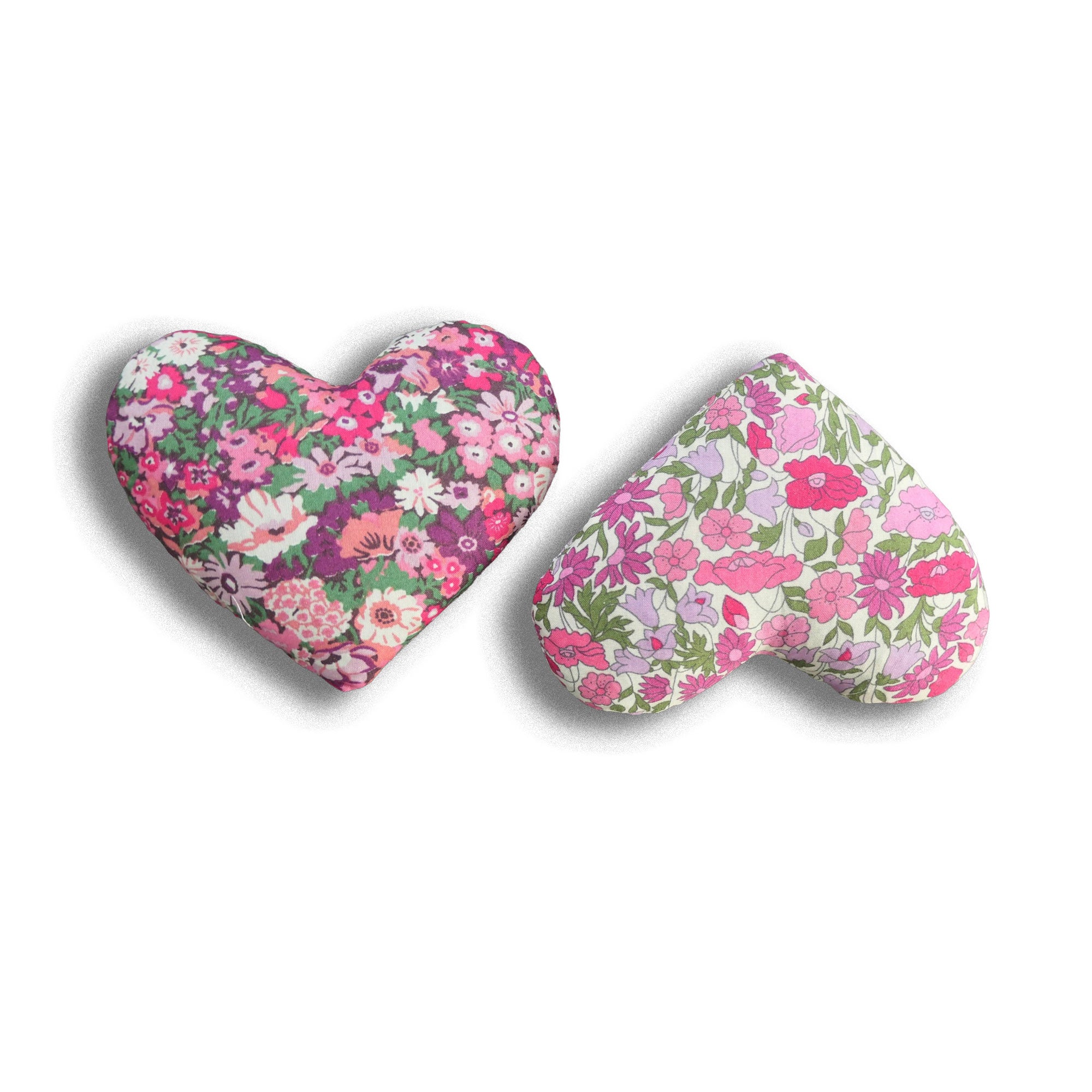 Two heart-shaped pink floral pillows on a white background