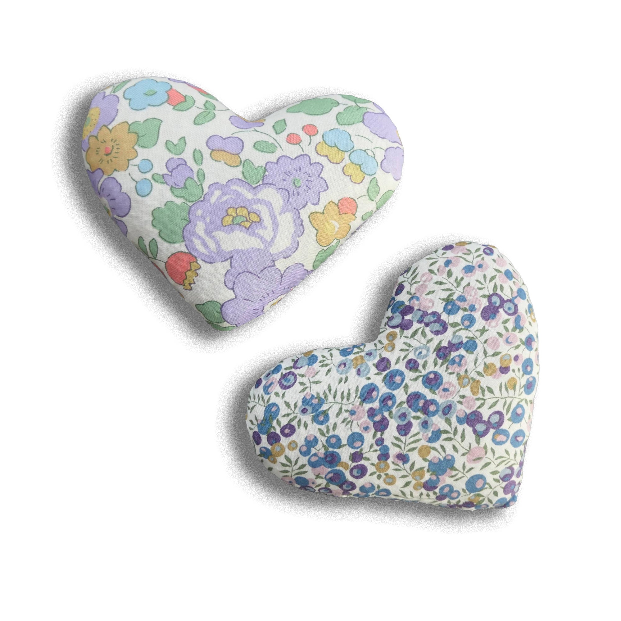 Floral-patterned heart-shaped and crescent-shaped cushions on a white background