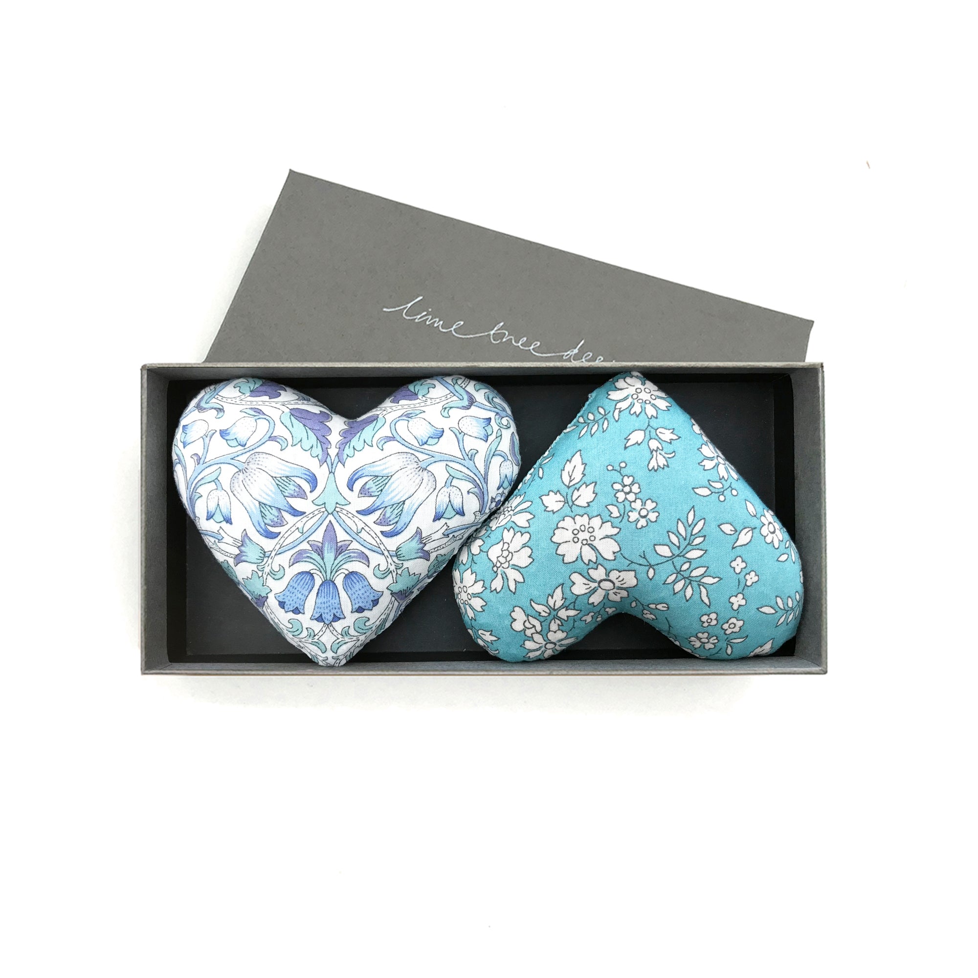 Two heart-shaped decorative lavender pillows with floral patterns in a box labeled 'Lime Tree Design'.