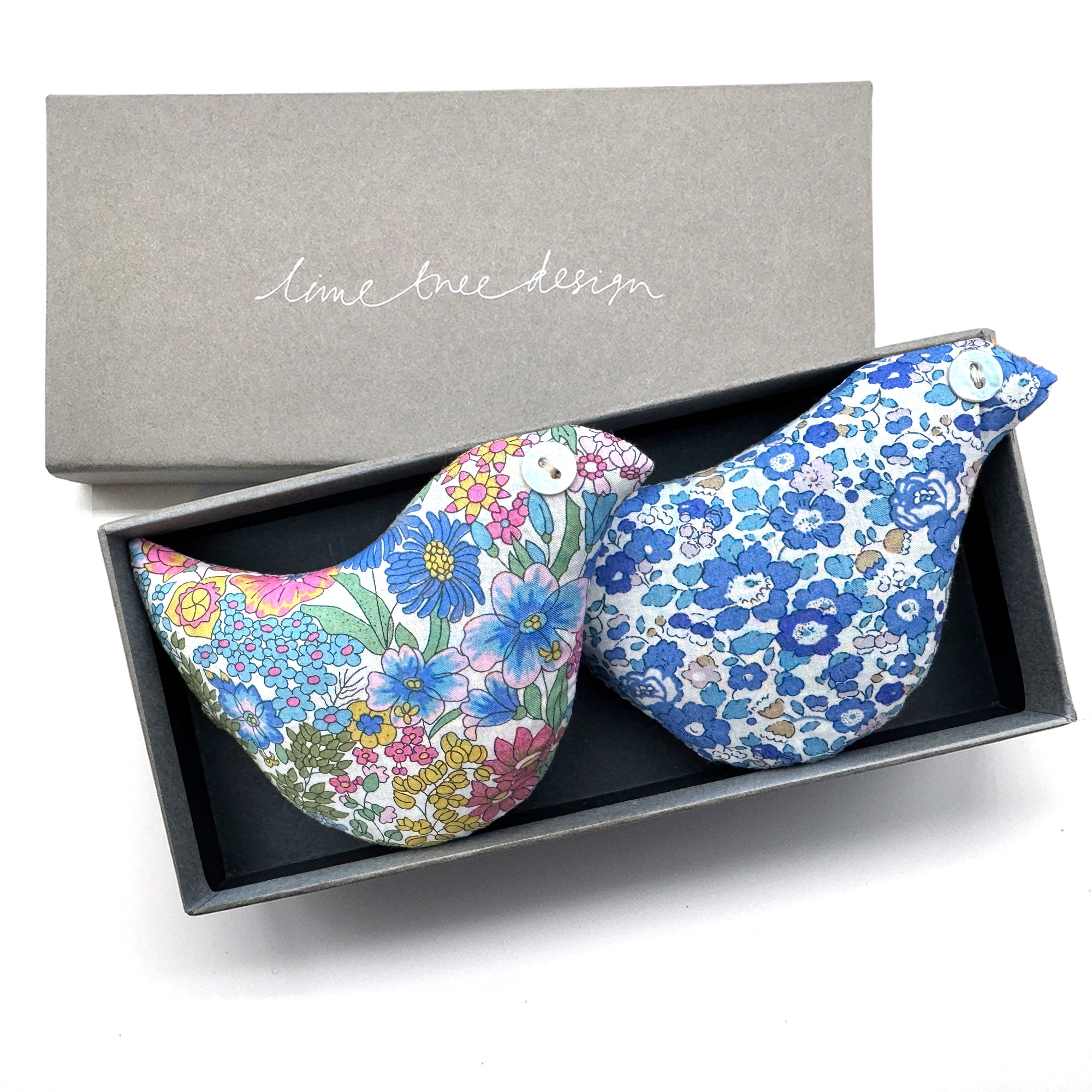 Two floral-patterned bird-shaped lavender pillows in a box with 'lime tree design' branding.