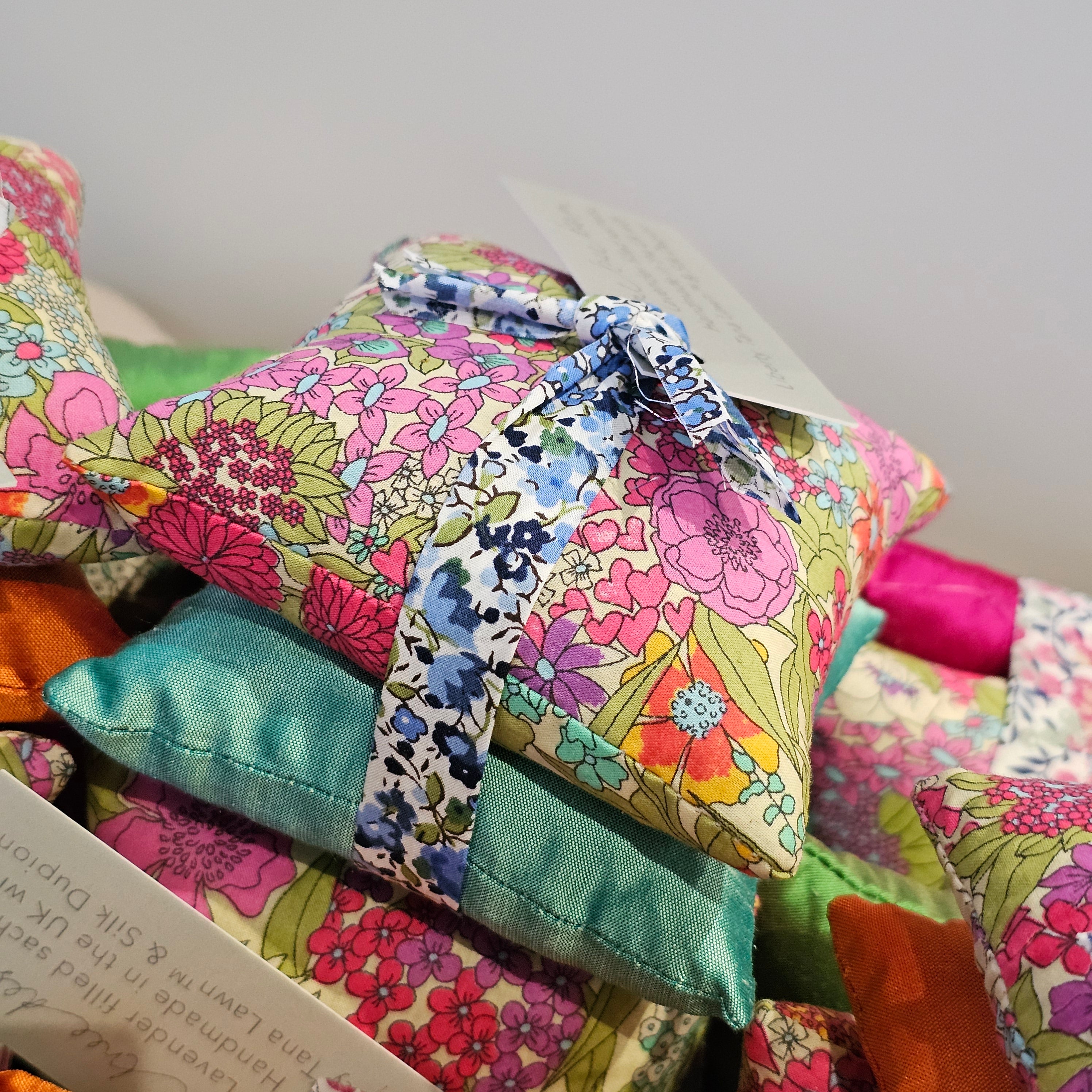 Colourful fabric flowers tied together with a decorative ribbon on a white background