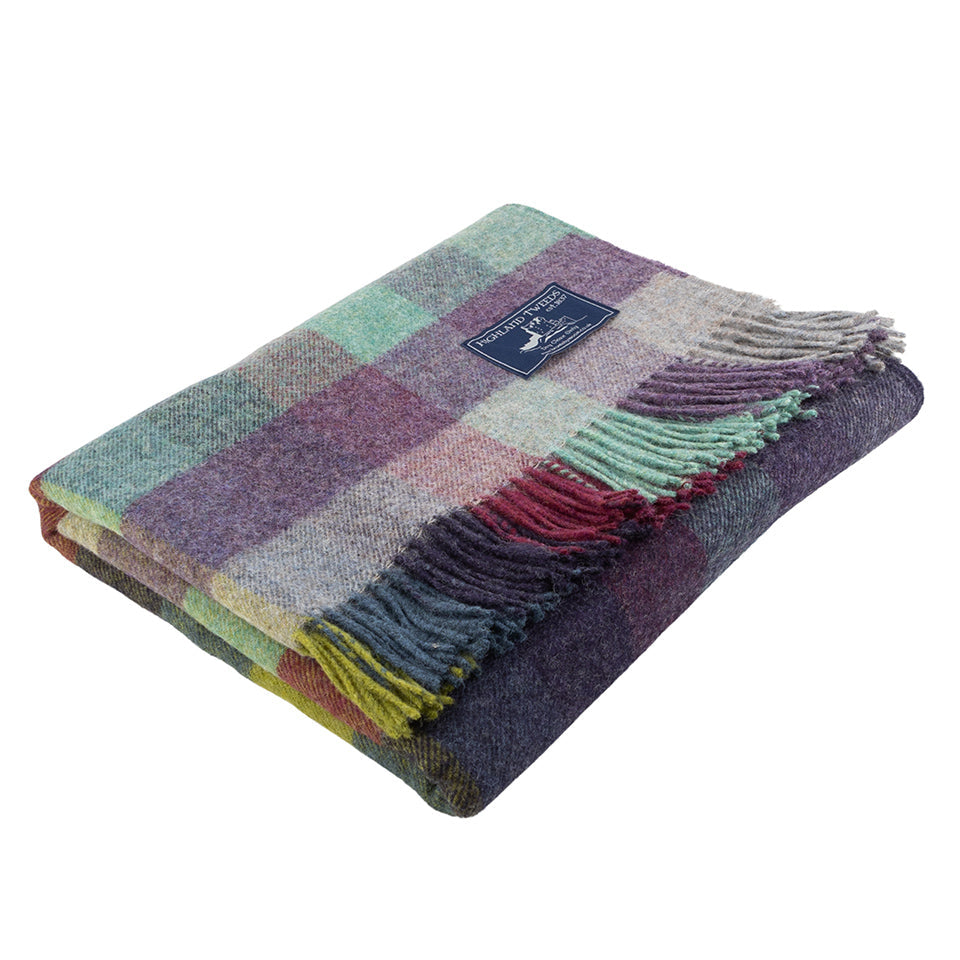 Multicolored checkered blanket with fringes on a white background