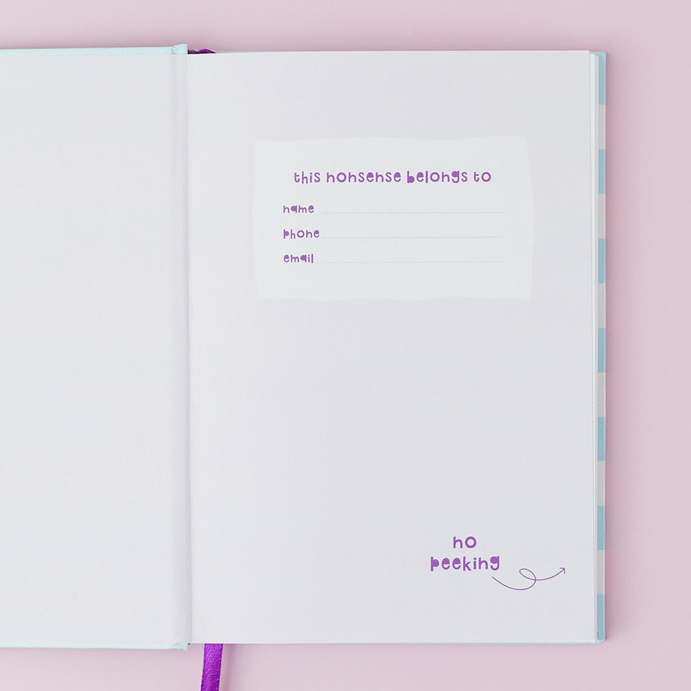 Open notebook with purple text on a pink background