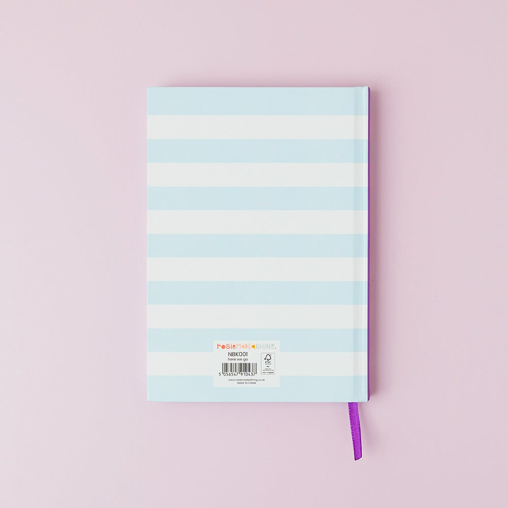 Notebook with pastel blue and white striped cover on a pink background