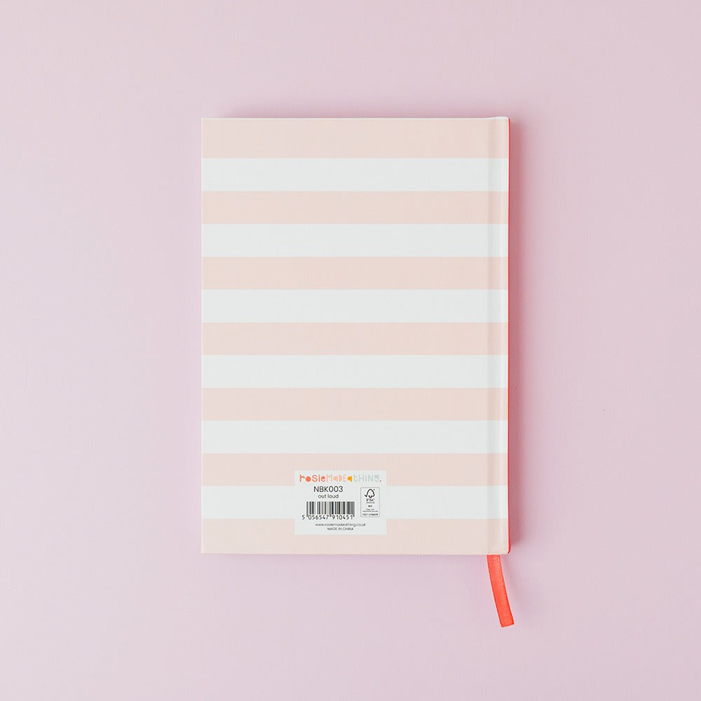 Notebook with pastel striped cover on a pink background