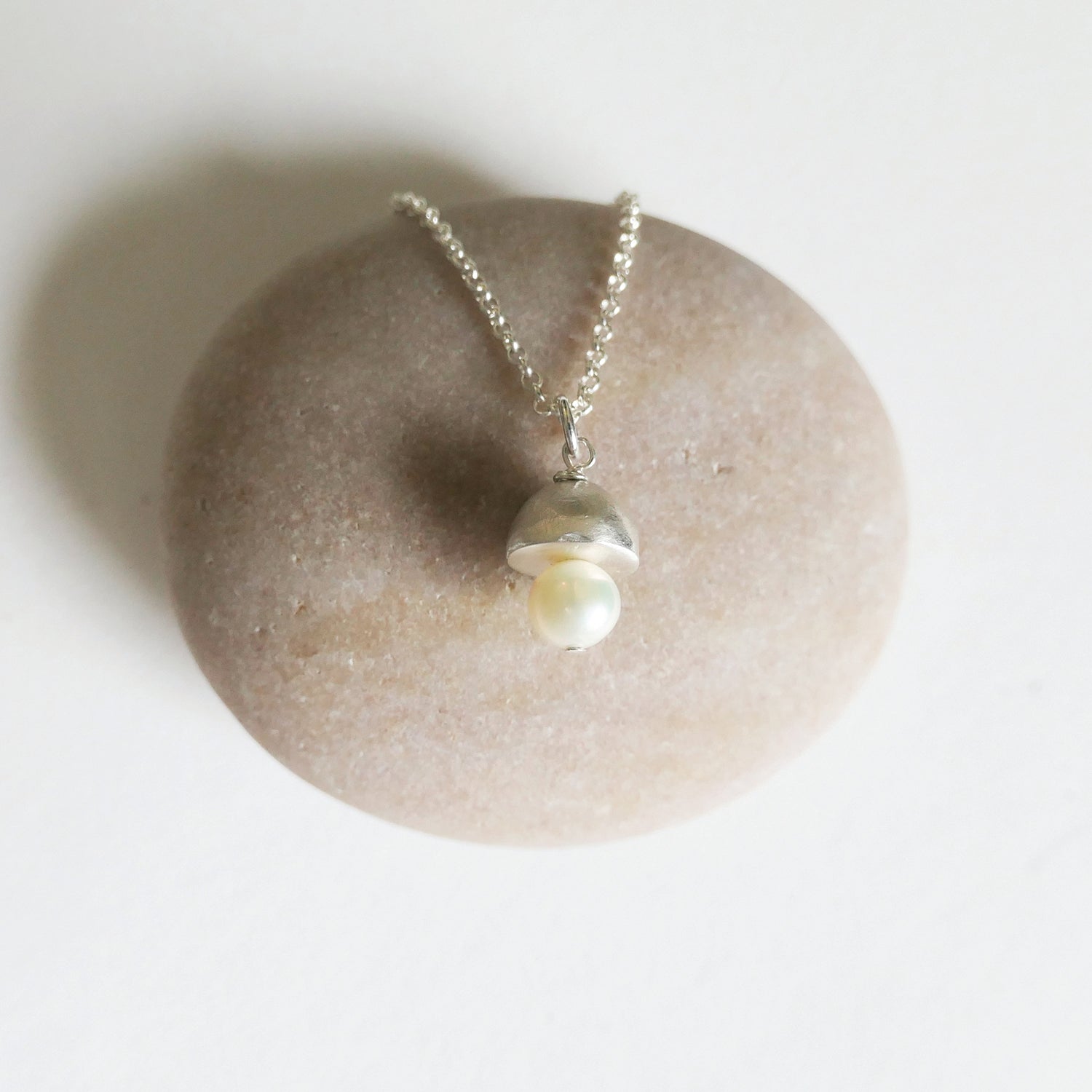 Pearl necklace on a stone with a white background