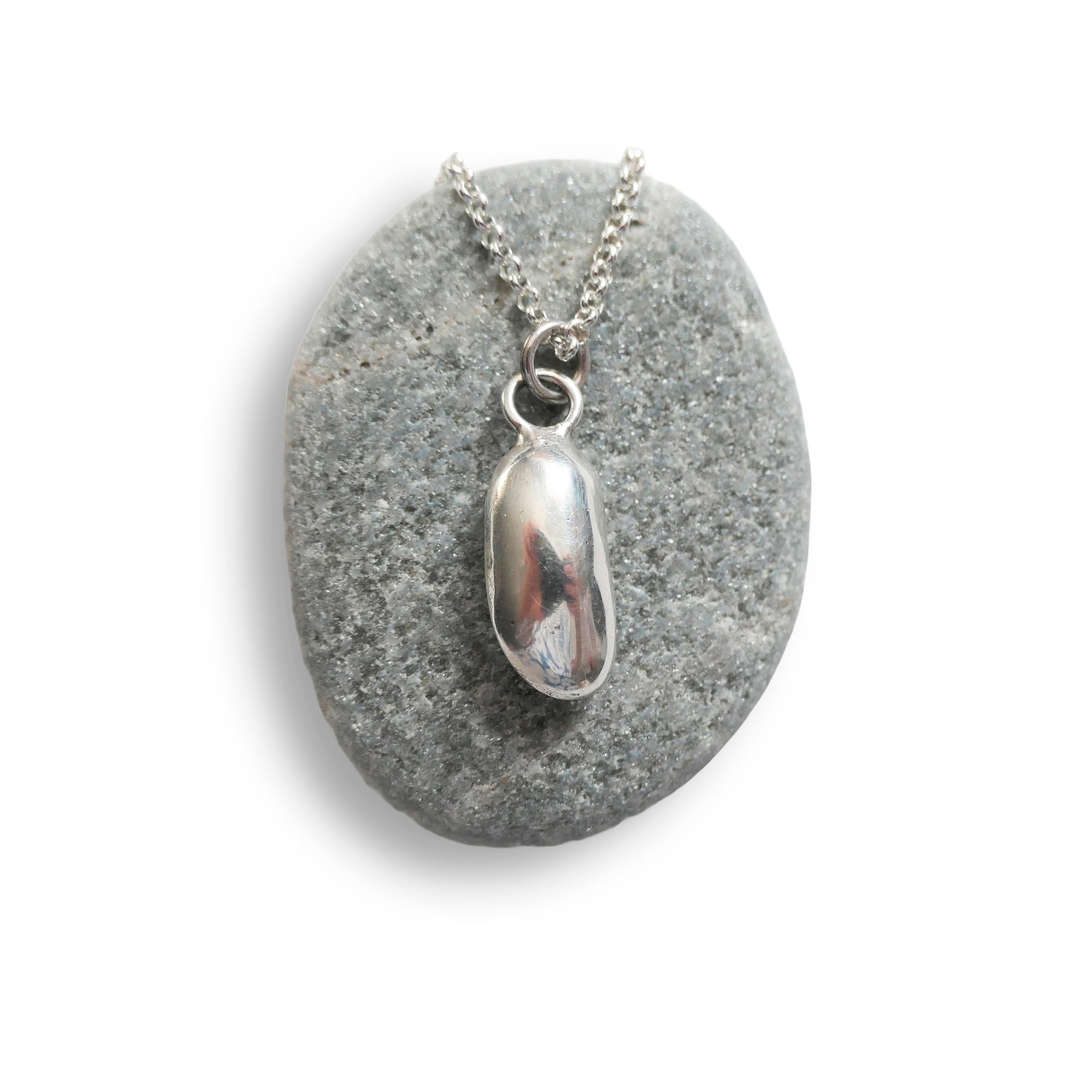 Silver pendant necklace on a gray stone