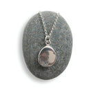 Silver necklace with a pendant on a gray stone