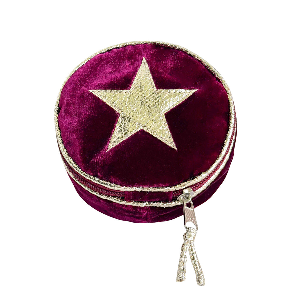 Round purple velvet jewelry box with a gold star and tassel on a white background