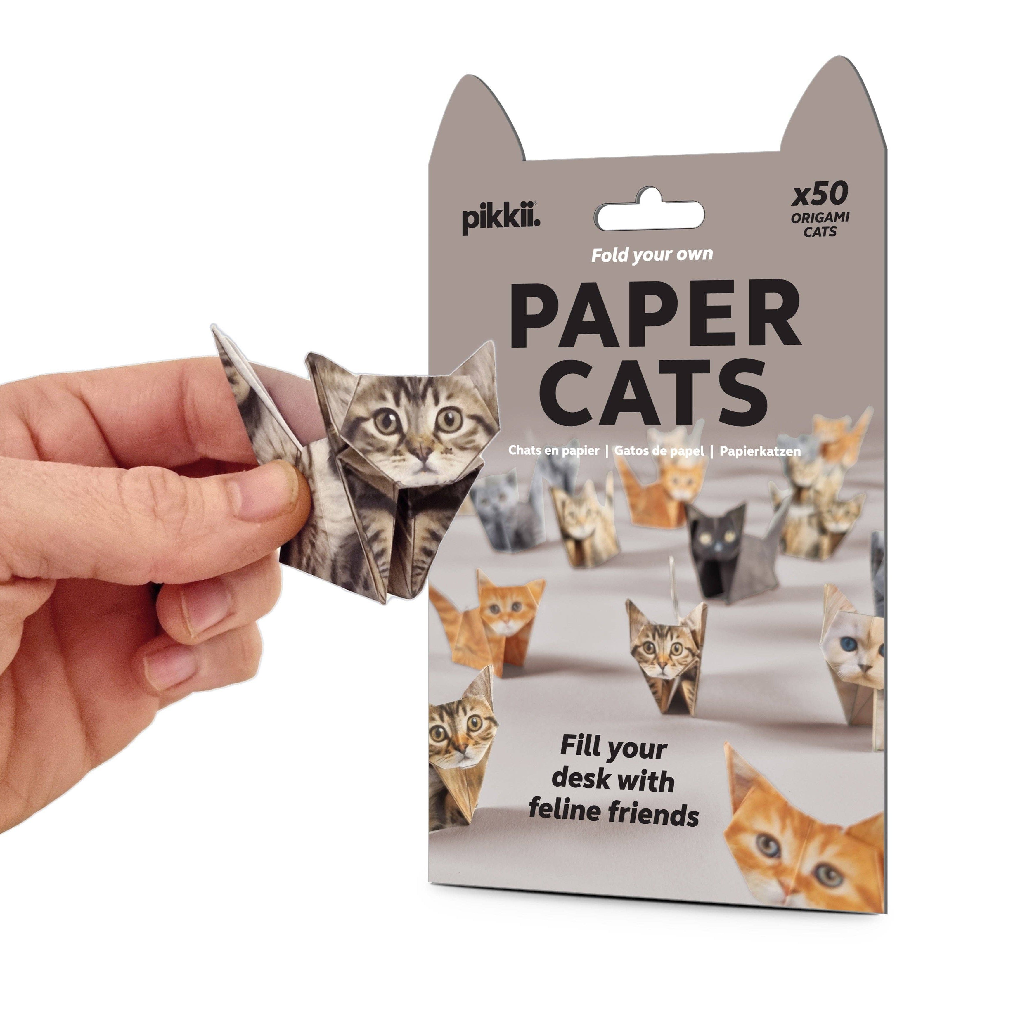 Package of paper cats with a hand holding one, on a white background