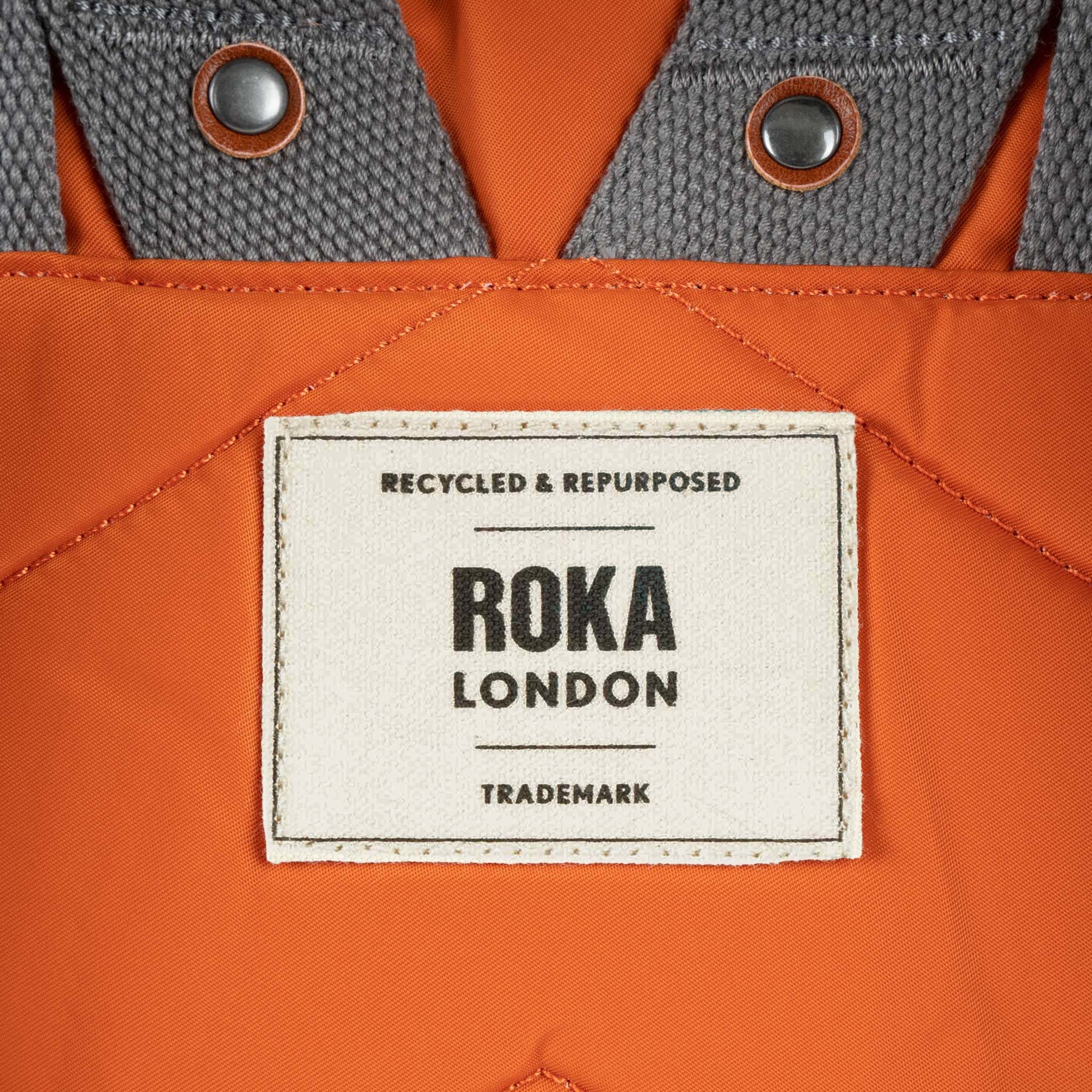 Roka London label on an orange and gray jacket