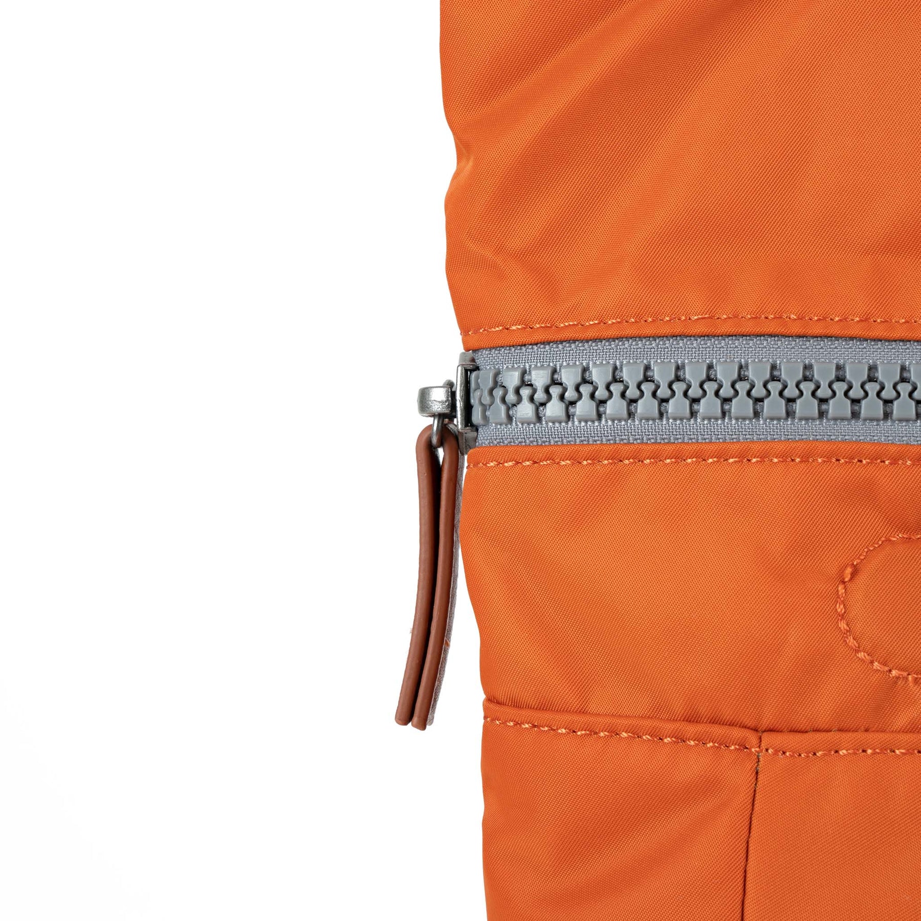 Close-up of an orange jacket with a zipper on a white background