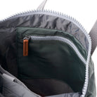 Close-up of a backpack zipper with a brown pull tab on a white background
