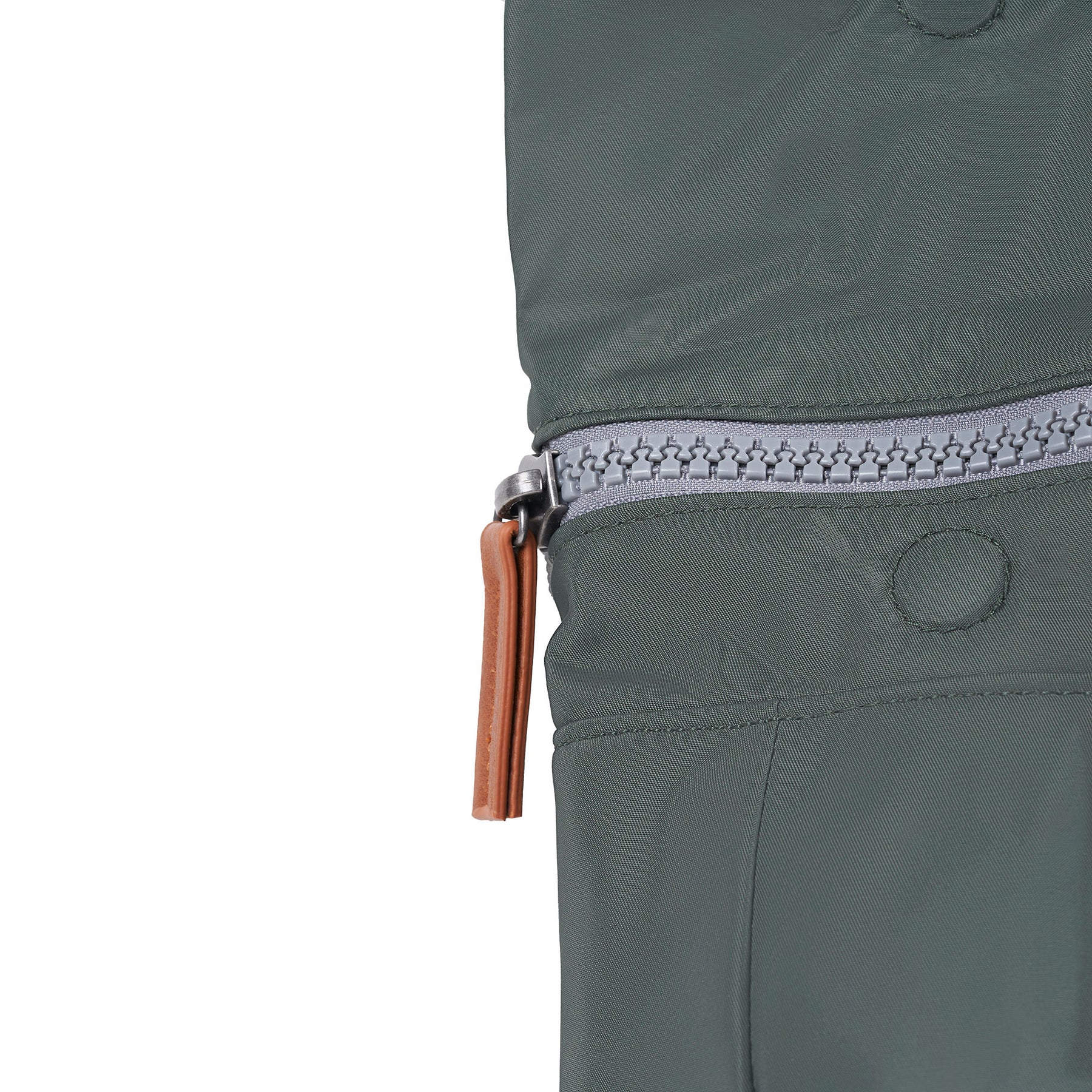 Close-up of a green jacket with a zipper and brown pull tab on a white background