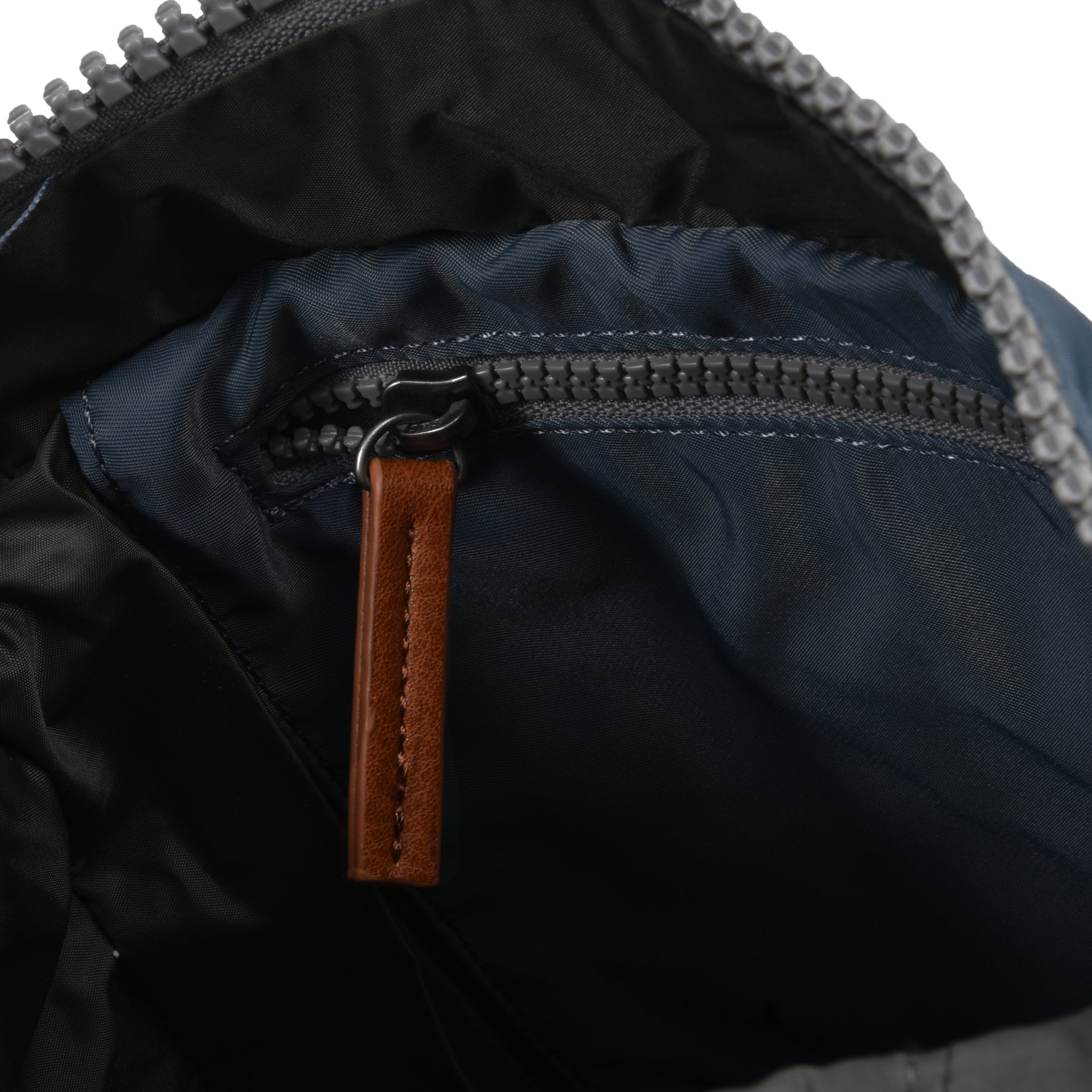 Close-up of a zipper on a jacket with a leather pull tab.