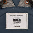 Roka London label on a blue fabric background