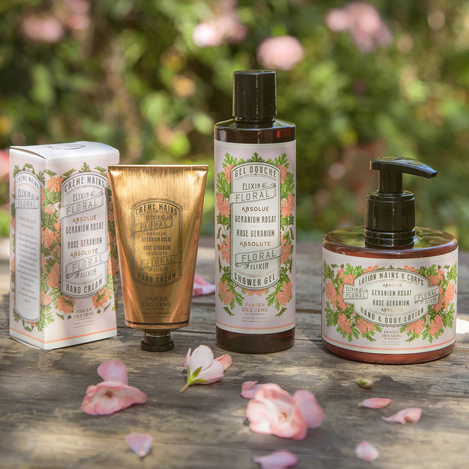 Set of rose skincare products on a wooden surface with floral background