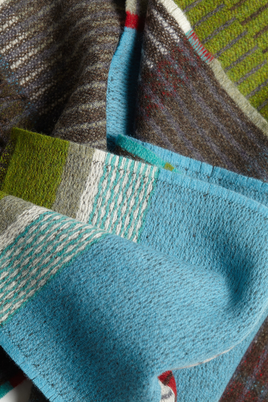 Close-up of a textured fabric with a blue section and multicolored background