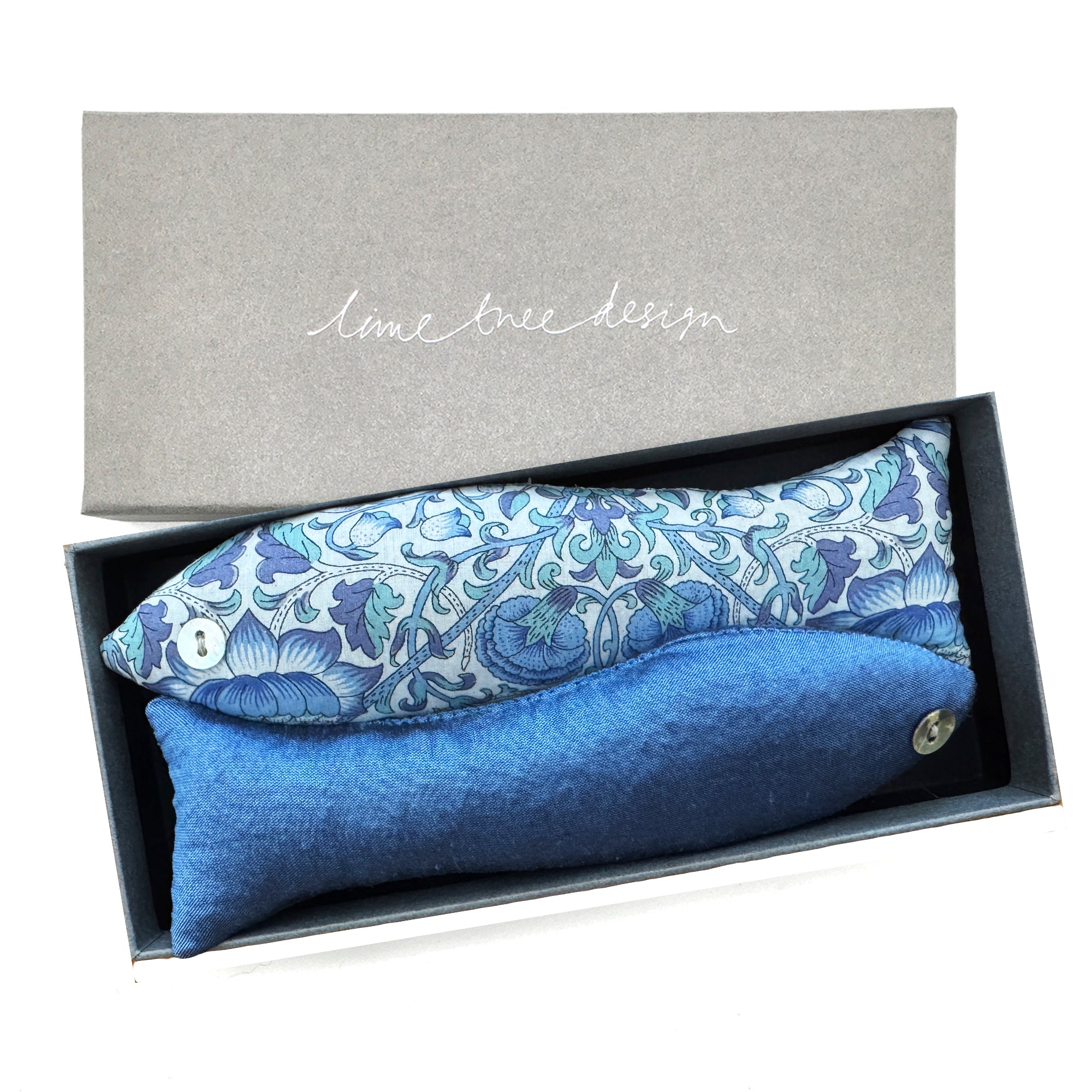 Blue floral-patterned fish shaped lavender sachet and plain blue fish shaped lavender sachet in a box with 'lime tree design' branding.