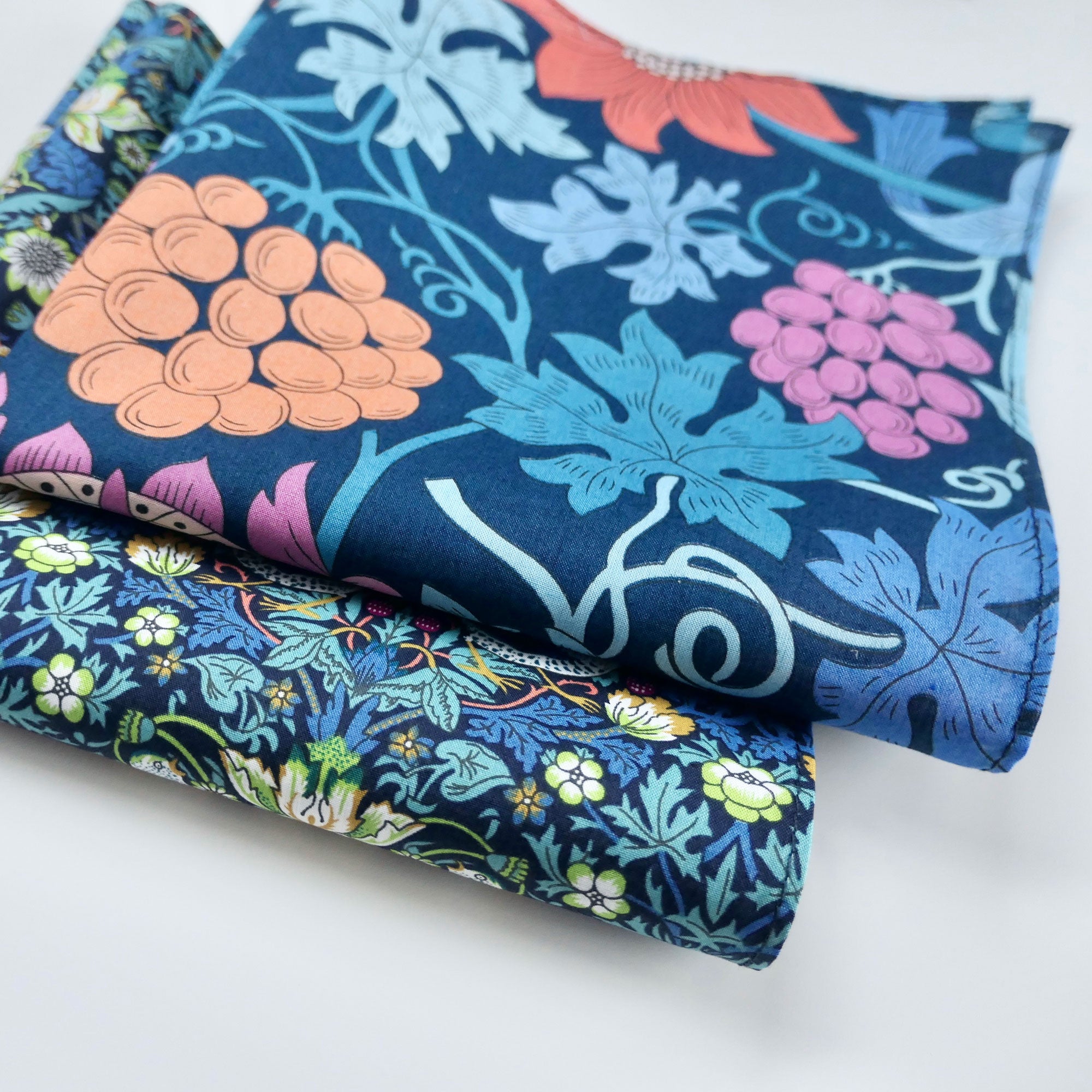 Stack of colorful floral fabric hankies on a white background