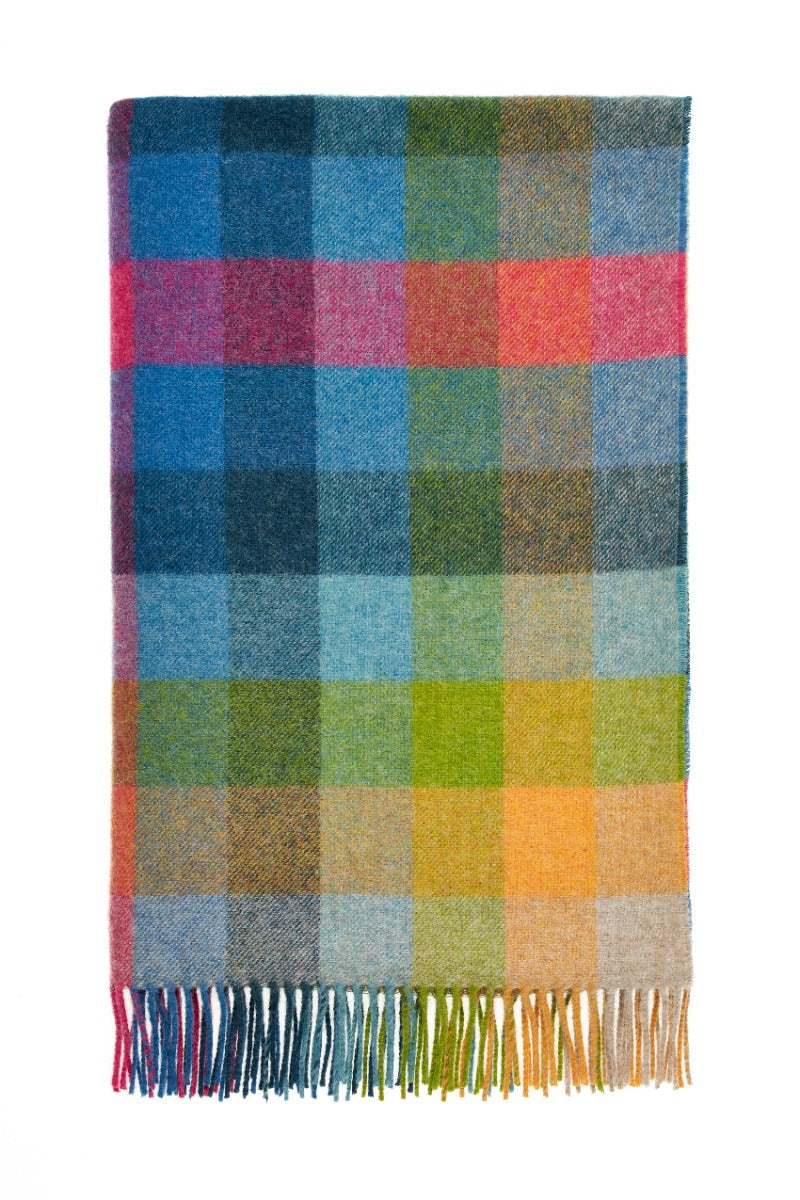 Multicolored checkered blanket with fringes on a white background