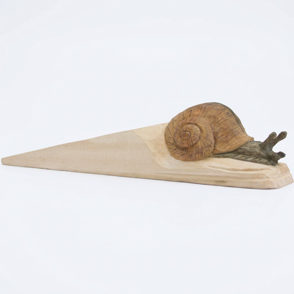 Decorative snail carving on a wooden door stop
