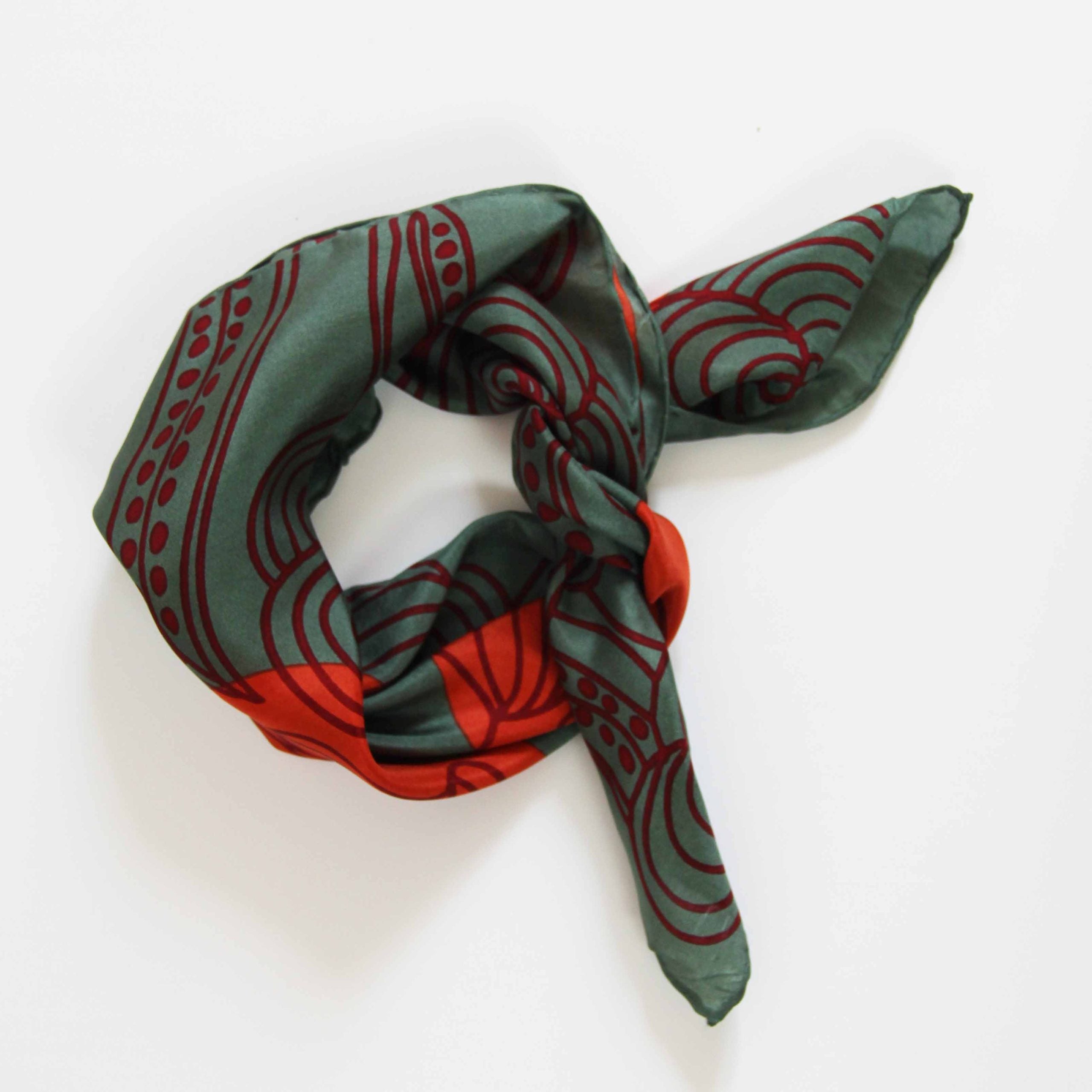 Green and red patterned scarf on a white background