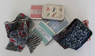 Collection of patterned fabric swatches and playing card boxes on a white background