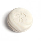 Round white ceramic object with a mushroom design on a white background