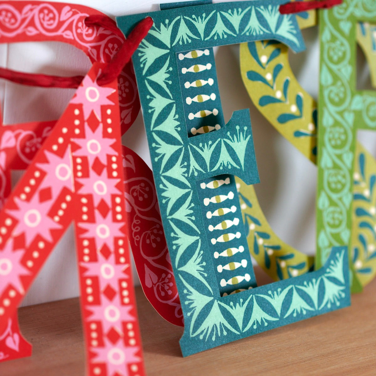 Decorative letters with colorful patterns on a wooden surface