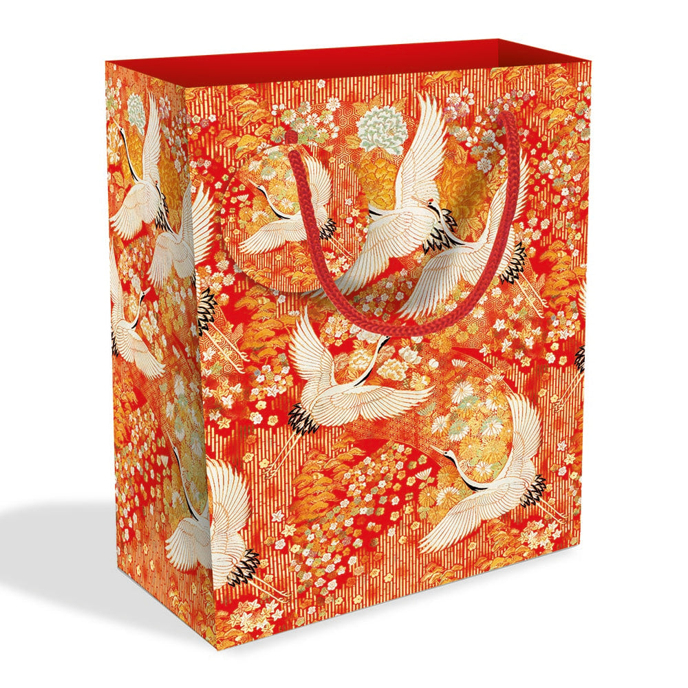 Short rectangular gift bag with pattern made up of white cranes against a red, orange and yellow floral background