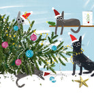 A whimsical holiday illustration of four cats dressed in Santa hats around a Christmas tree with colorful ornaments, set against a snowy light blue background.