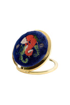 Compact mirror with embroidered design on a white background